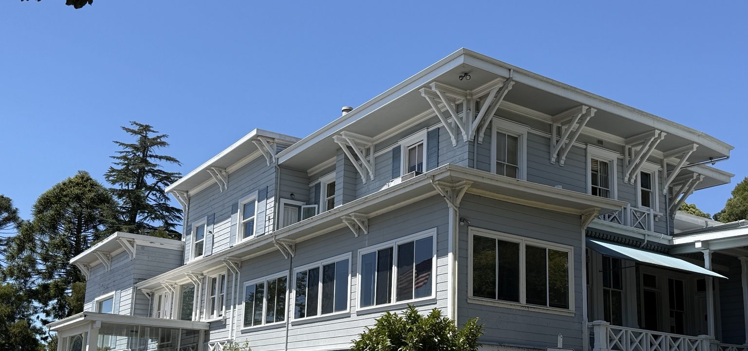 The Lodge today: two stories of pale blue clapboard with white trim, seen from the parking lot.